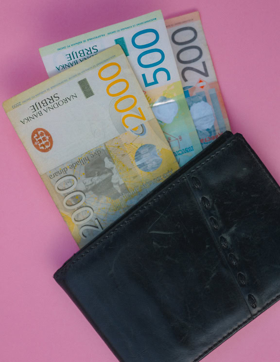 A black leather wallet with money in it, banknotes of 200, 500 and 2000 Serbian dinars