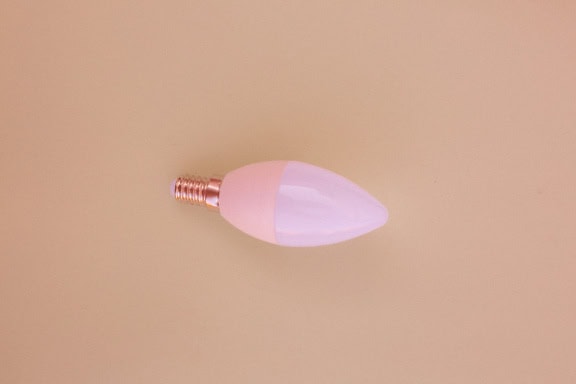 Energy-saving light bulb with a light-emitting diode on a beige background