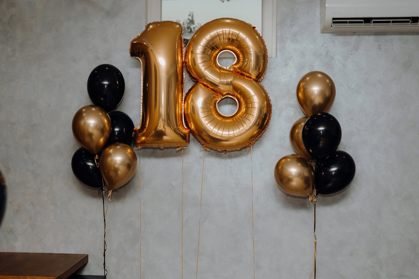 Ballons à l’hélium dorés et noirs en forme de numéro dix-huit (18) comme décorations de fête d’anniversaire