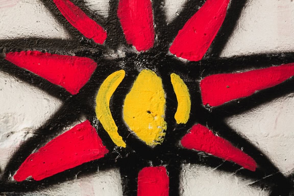 An artistic graffiti of a Sun painted with a dark red and black paint