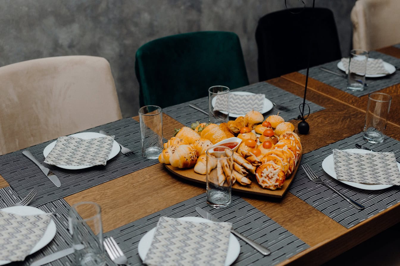 Ein Teller mit Mini-Sandwiches und Burgern als Vorspeise auf dem Tisch