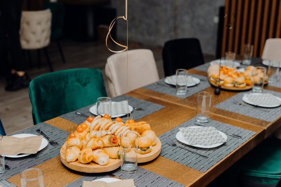 Tafel met fastfood erop, diverse miniatuur broodjes en hamburgers als voorgerecht