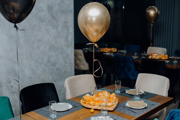 Interior of a restaurant with plate of food on a table and with a balloon