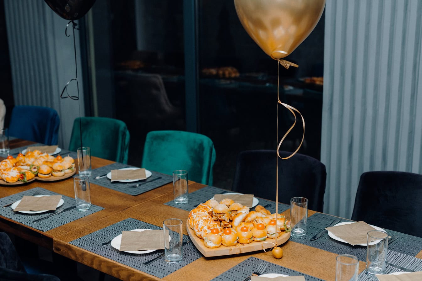 Eettafel in een kamerset met plaat met broodjes, snacks en ander fastfood