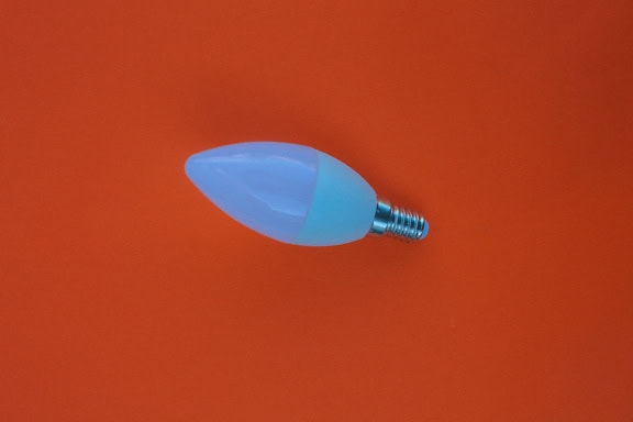 Une ampoule à économie d’énergie avec diode électroluminescente (LED) avec douille (E-21 5W) sur fond orange