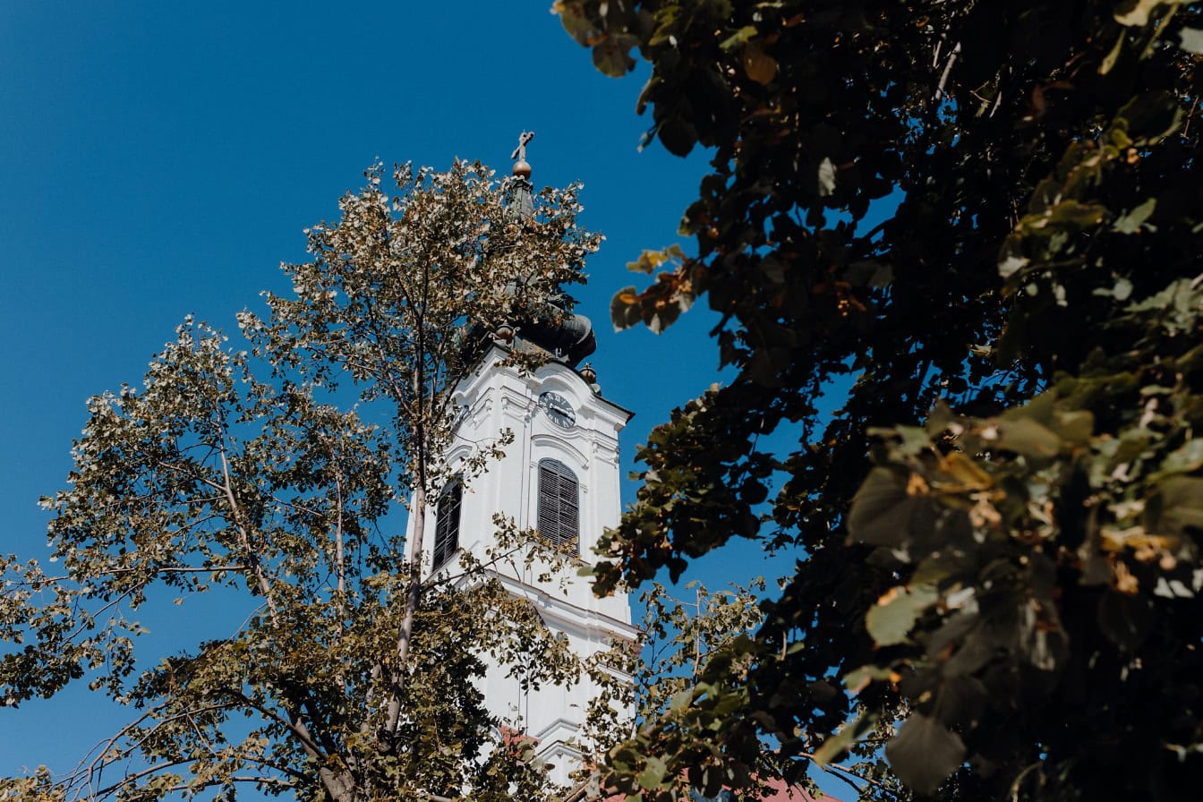 Torre sineira branca com uma cruz no topo da igreja ortodoxa sérvia da Natividade de São João Batista, Backa Palanka, Sérvia