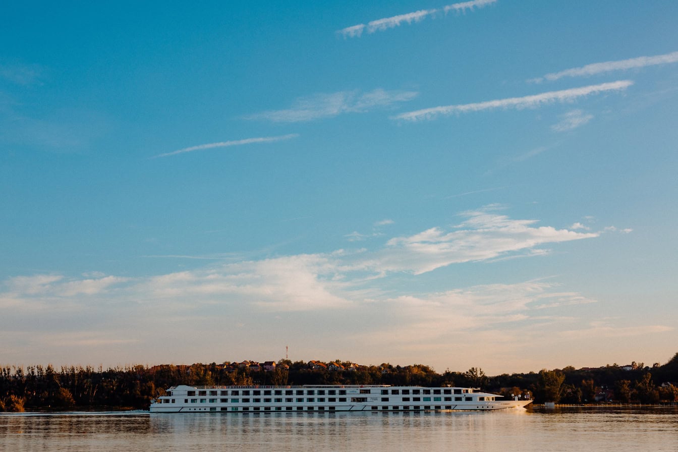 Vista laterale di una grande nave da crociera bianca sul fiume, un’attrazione turistica del corso d’acqua del Danubio