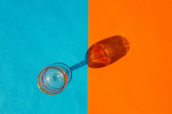 A glass made of lead or crystal glass on two tone blue and orange background