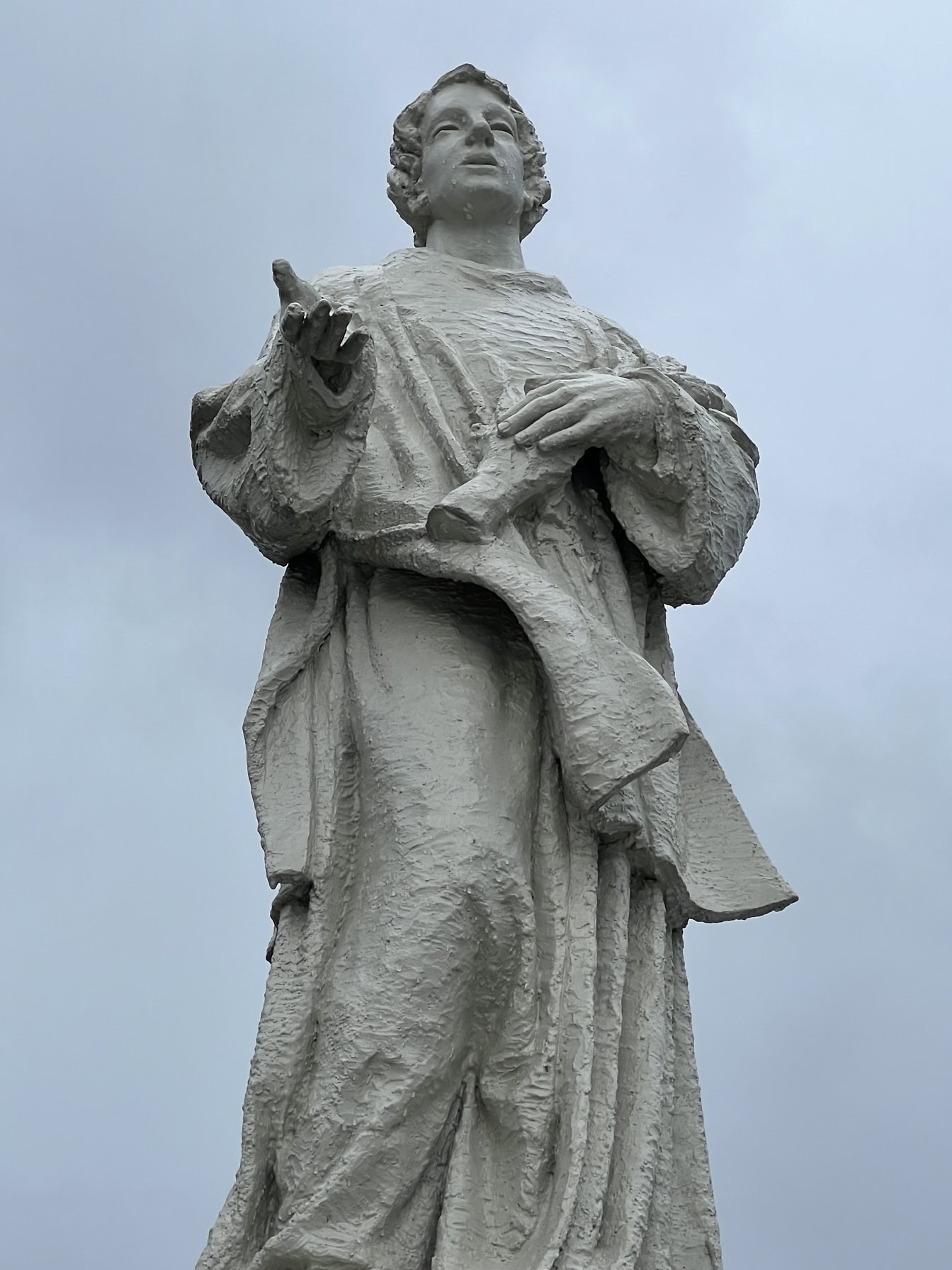 Statue of a man in a robe with bluish background