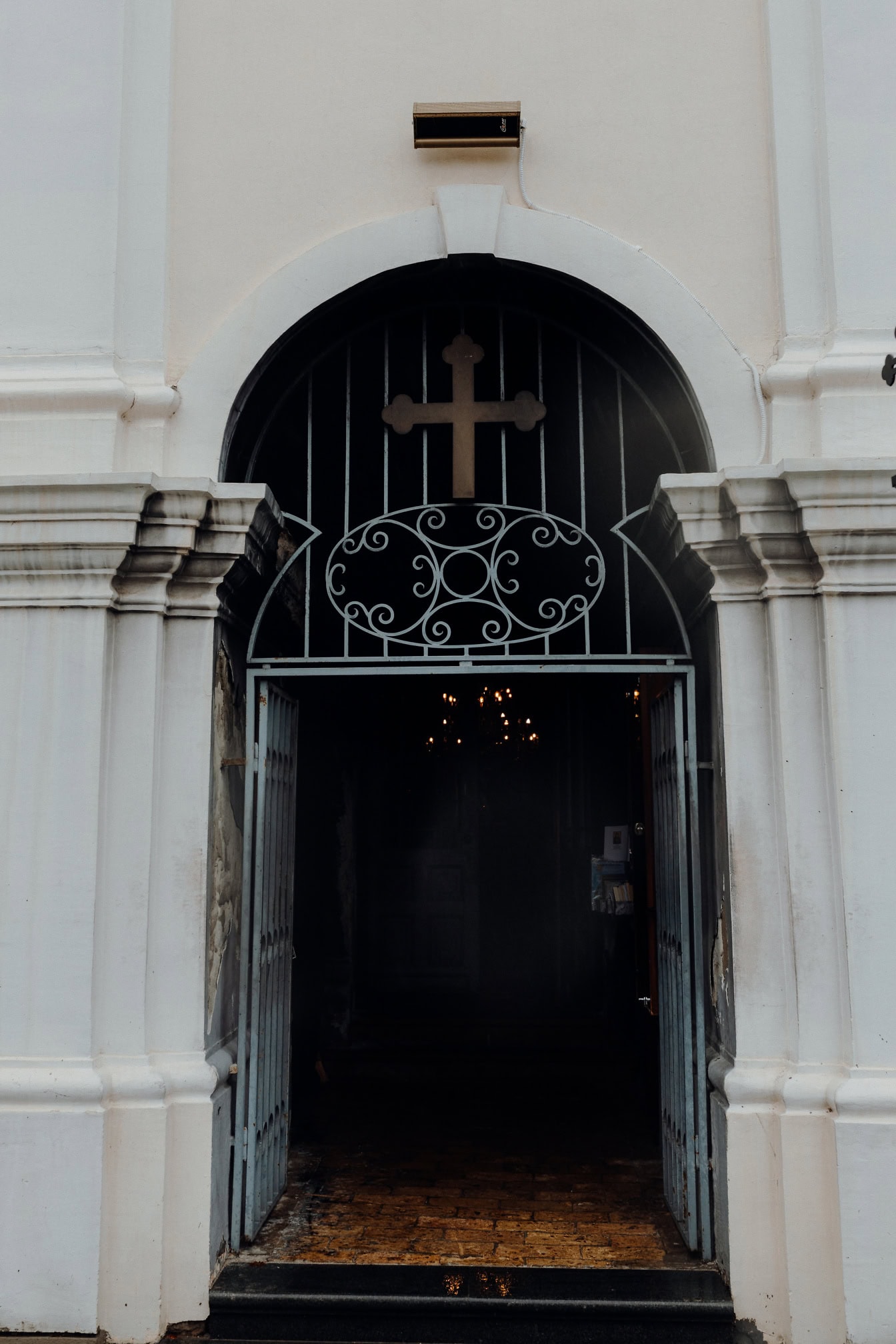 Uma porta de ferro fundido com uma cruz acima dela na porta de entrada do mosteiro