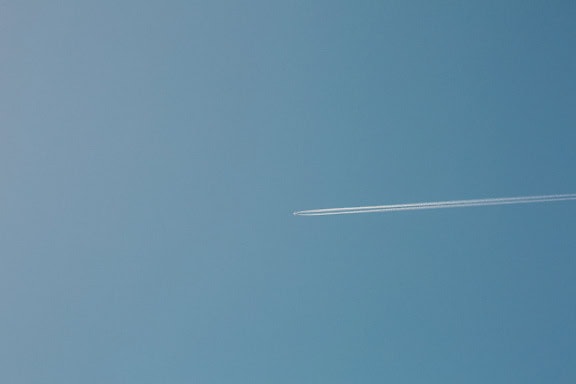 澄み切った青空を飛ぶジェット機