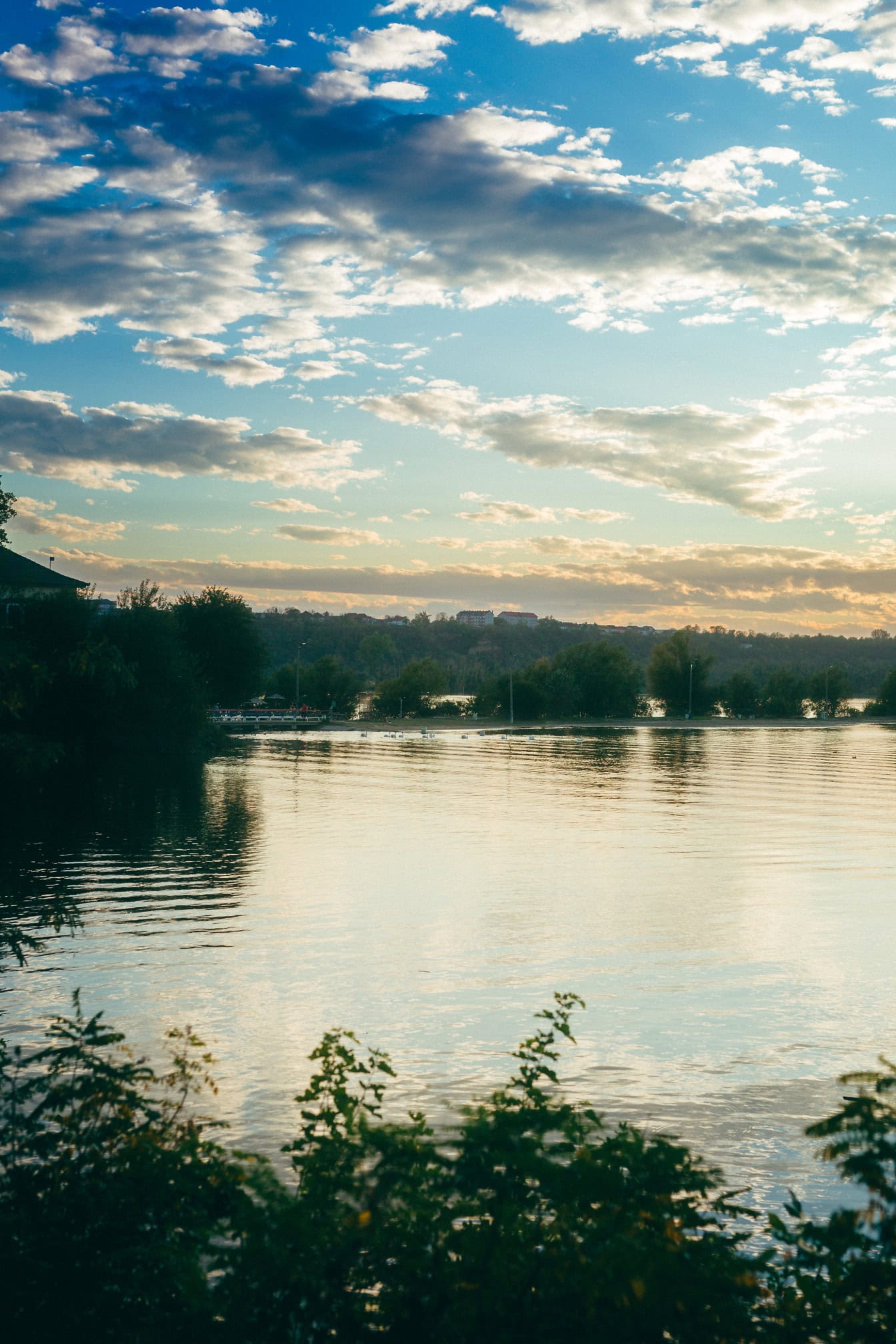 După-amiaza la lacul Tikvara cu copaci și nori albi pe cerul albastru