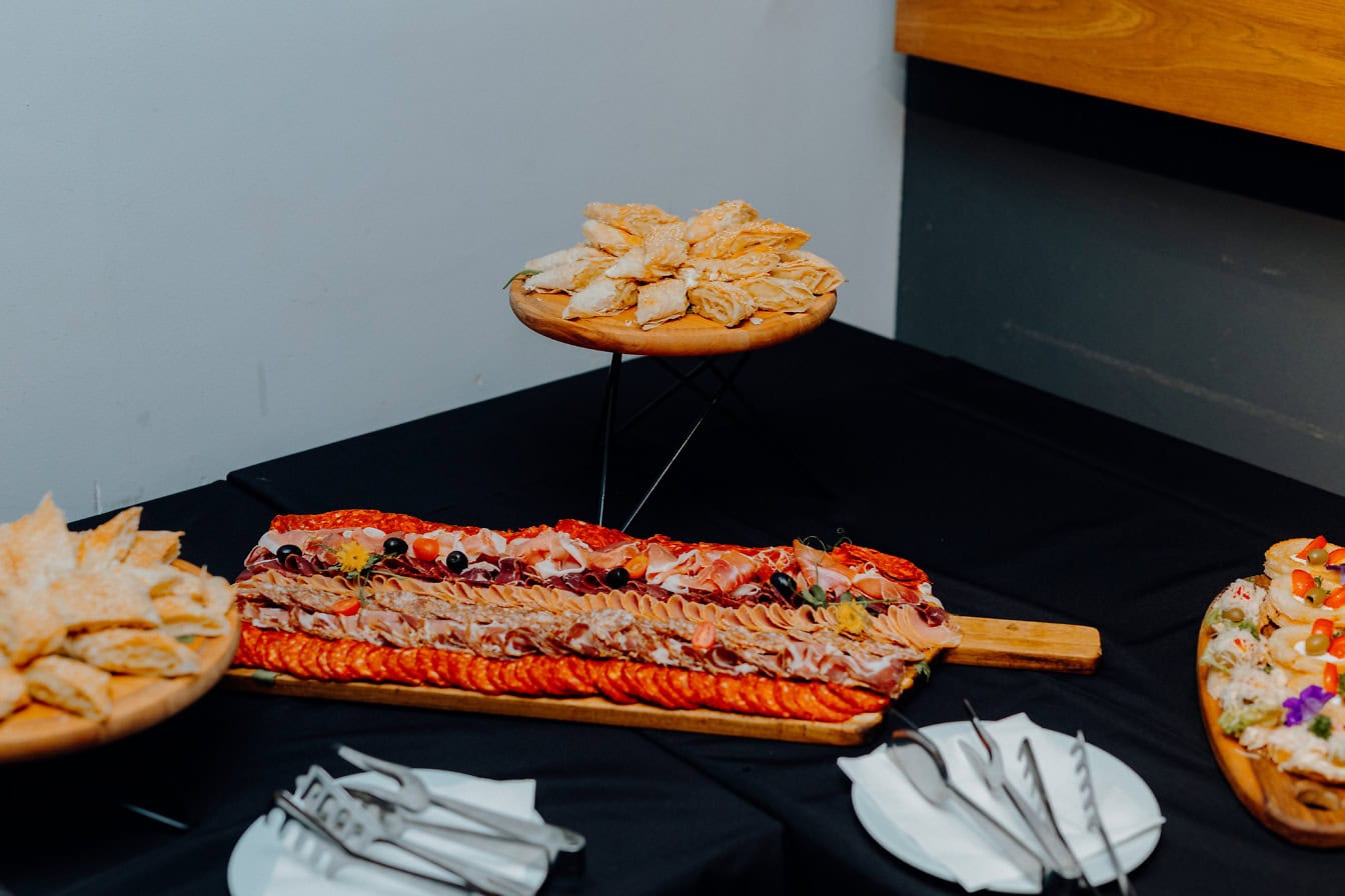 Table avec une assiette de tartes et un plateau en bois avec une variété d’entrées