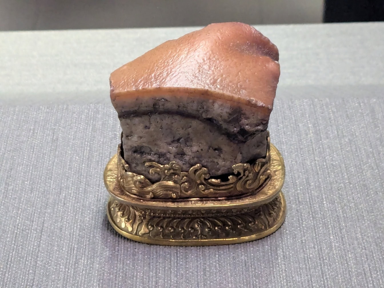 A pedra dada forma carne mundialmente famosa da dinastia de Qing, uma pedra dada forma barriga de porco em uma placa de ouro em um museu do palácio nacional de Taipei, Formosa