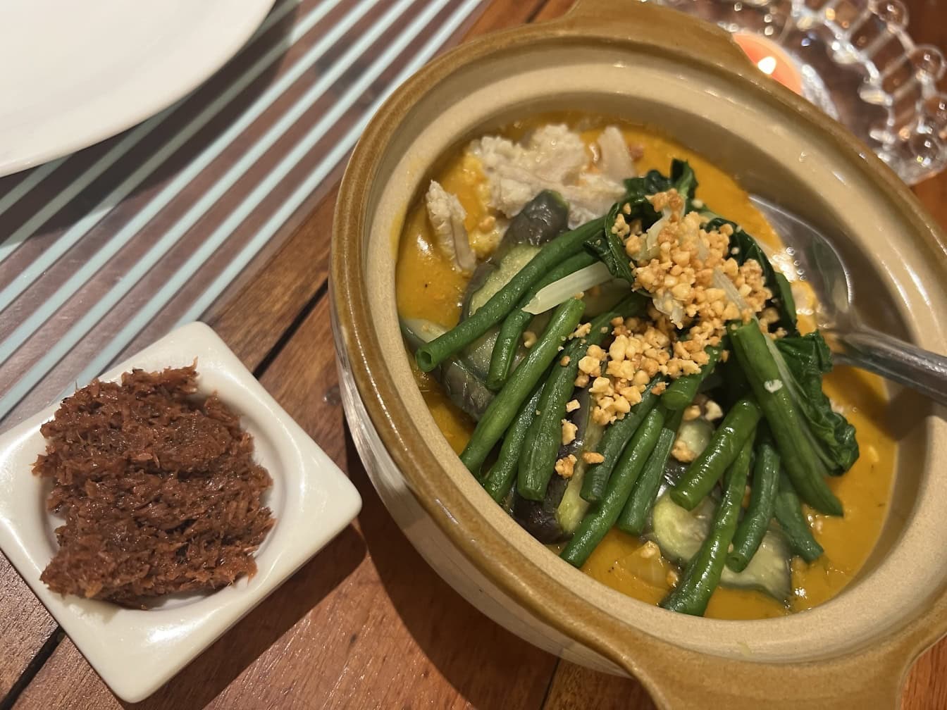 Plato de sopa de verduras con judías verdes y otras verduras en una mesa