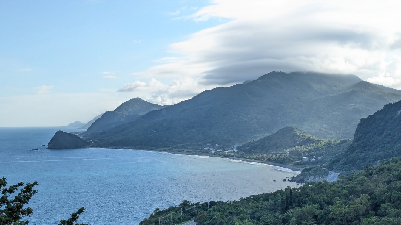 Garis pantai laut di dekat Hualien, Taiwan dengan latar belakang pepohonan dan pegunungan