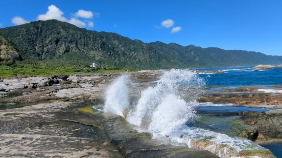 台湾沖の岩場の岩に水しぶきがかかる