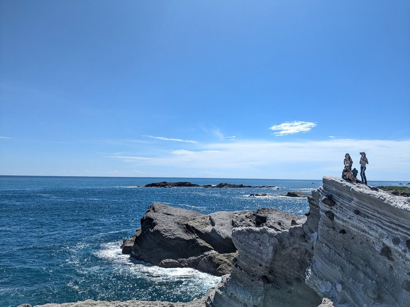 Orang-orang di bebatuan pantai, tebing yang menghadap ke laut, sudut pandang alam yang sempurna dengan panorama lanskap tepi laut, Taiwan