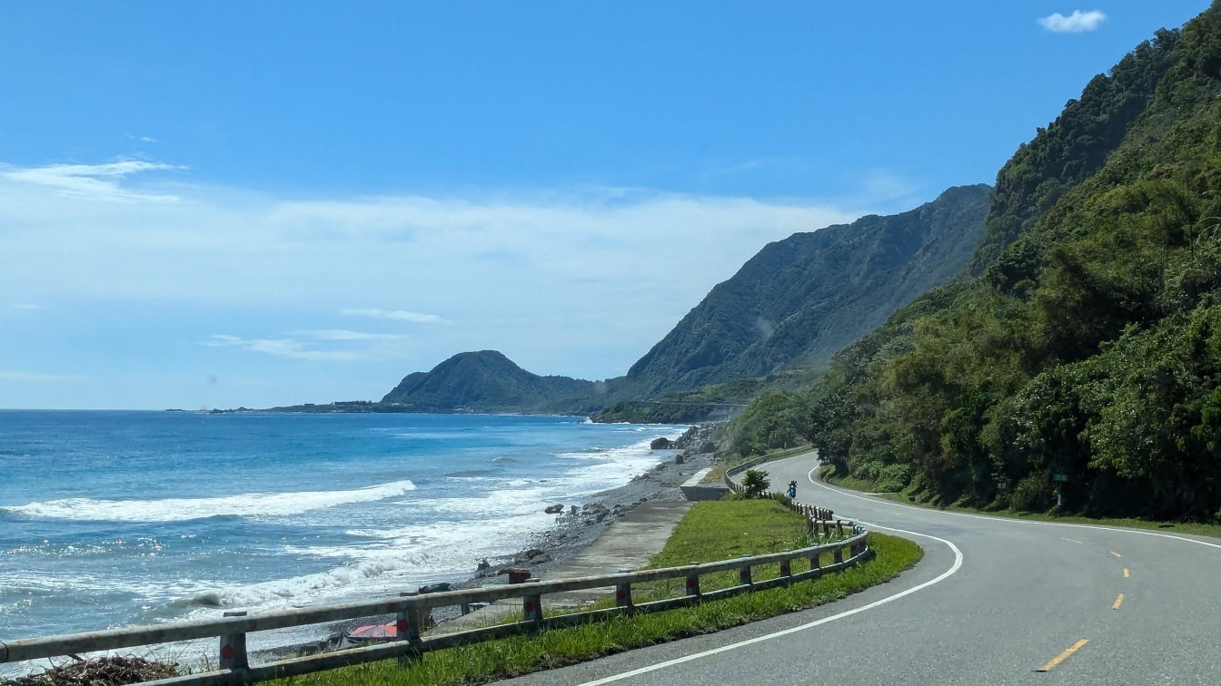 Asfaltweg voor de kust van Taiwan met overzeese golven die de kust bespatten