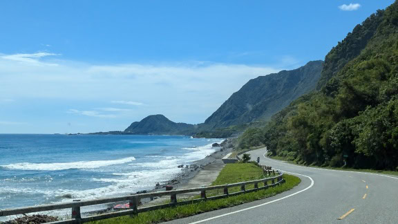 Asphalt road off the coast of Taiwan with sea waves splashing the coast