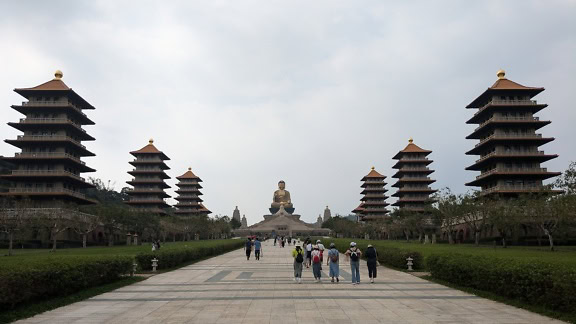 People walking on a path with a large statue of Buddha in the background at the Fo Guang Shan Buddha museum, Taiwan