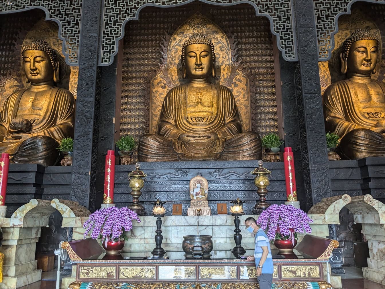 Majestátní zlaté sochy tří Buddhů ve svatyni kláštera Sangha Fo Guang Shan, buddhistického duchovního centra, Kaohsiung, Tchaj-wan