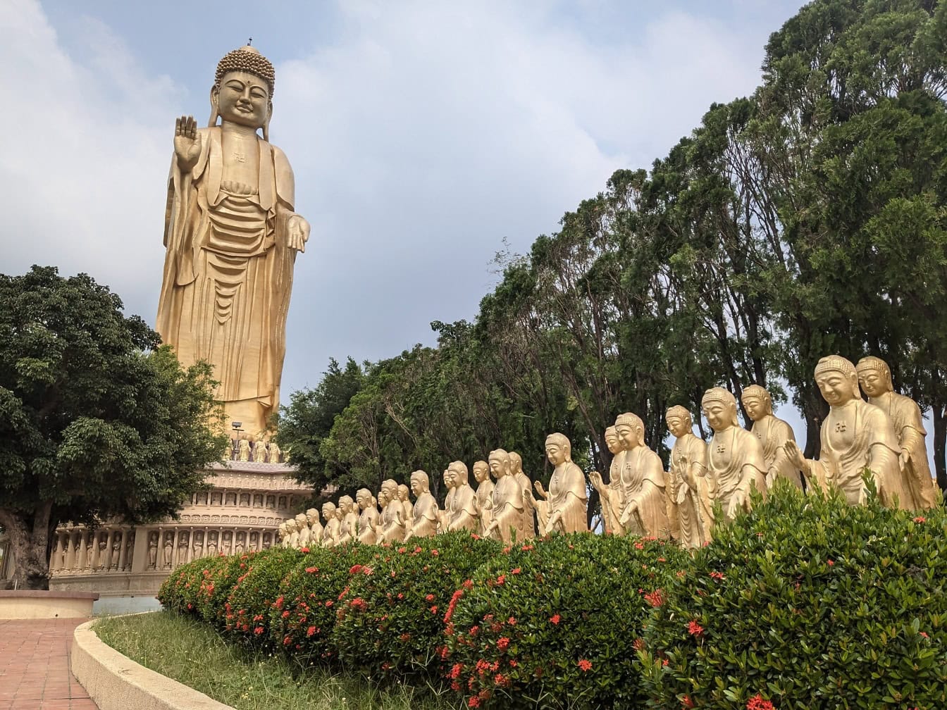 Grande statua d’oro di un Buddha con molte statue d’oro, un giardino di un tempio buddista a Kaohsiung, Taiwan