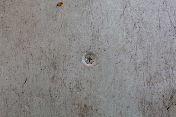 Galvanized screw in a dirty metal surface