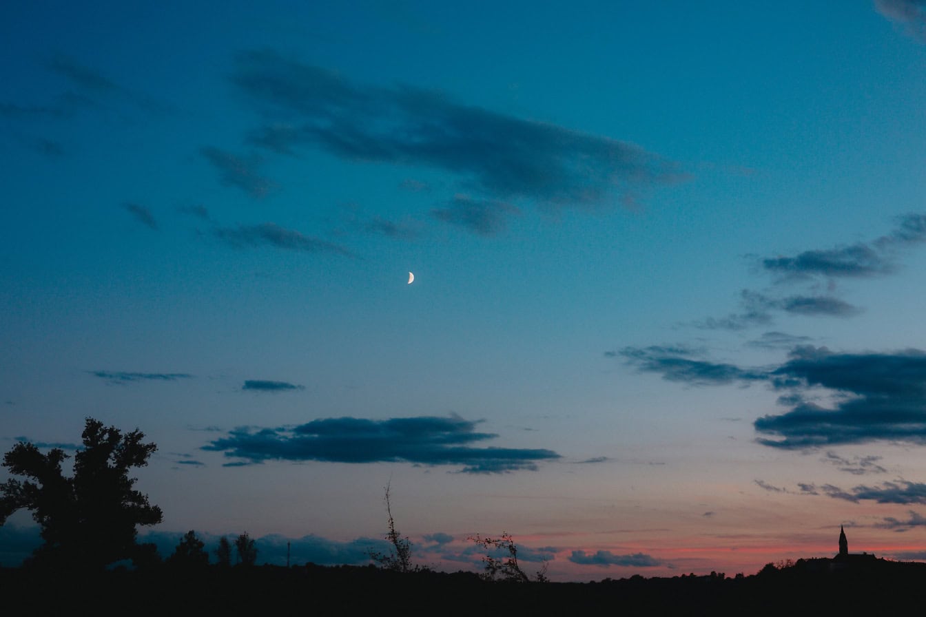 Et landskab med mørkeblå himmel med måneformørkelse og måneskin