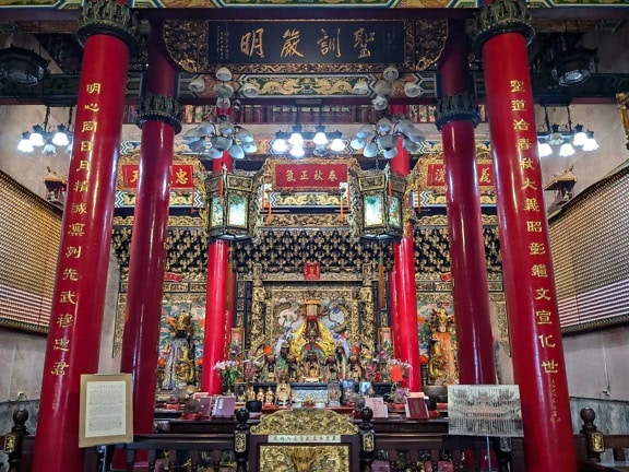 Shrine of Buddhist temple with red pillars and rich oriental ornament decorations