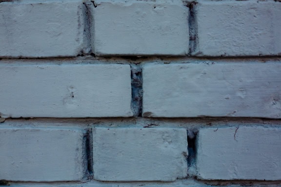 Brick wall painted with white paint, a close-up texture of bricks