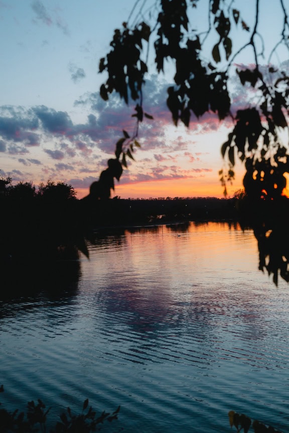 Matahari terbenam di atas danau saat senja