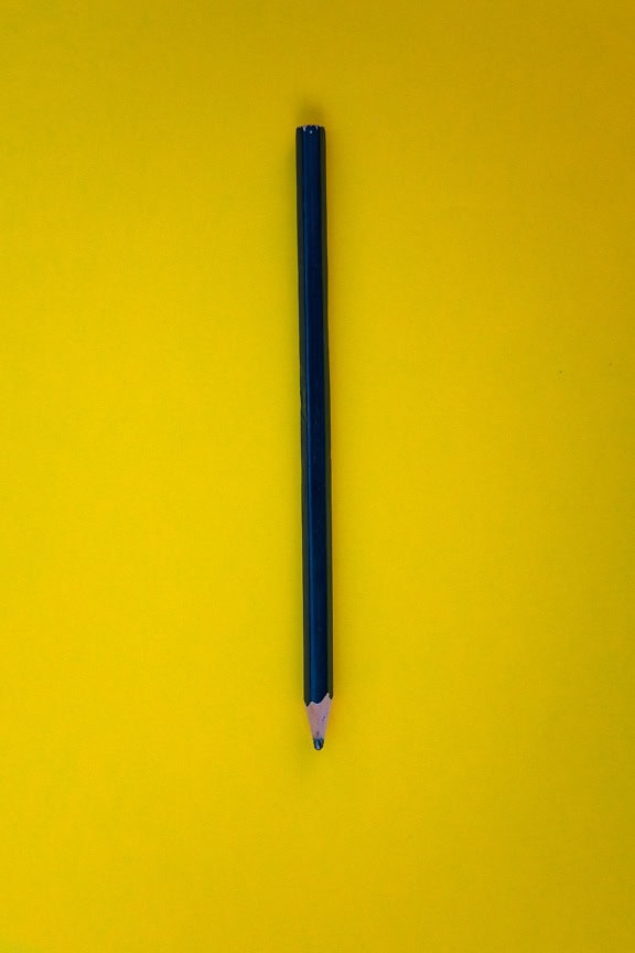 A black lead pen on a yellow surface