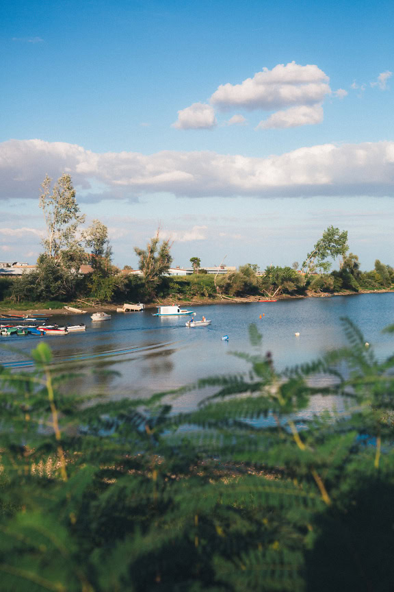 View of the marina for small motor boats from the shore overgrown with bushes