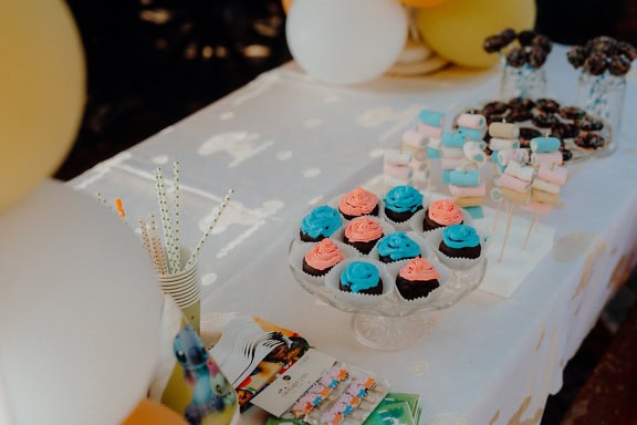 Una mesa con cupcakes, piruletas de chocolate y otros deliciosos dulces, una exhibición de alimentos en la mesa preparada para una fiesta de cumpleaños