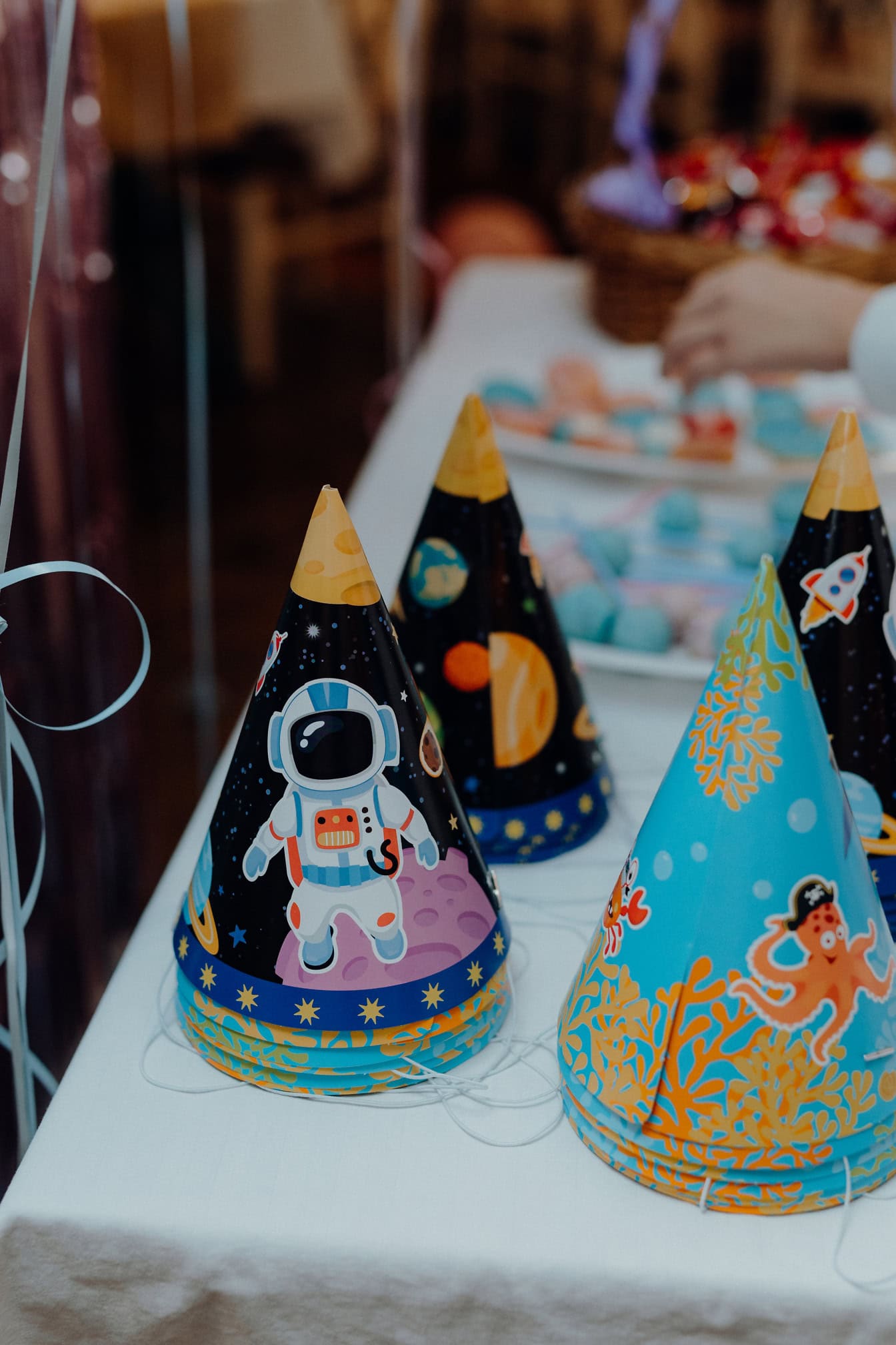 Coloridos gorros infantiles para una fiesta de cumpleaños con una ilustración de astronautas