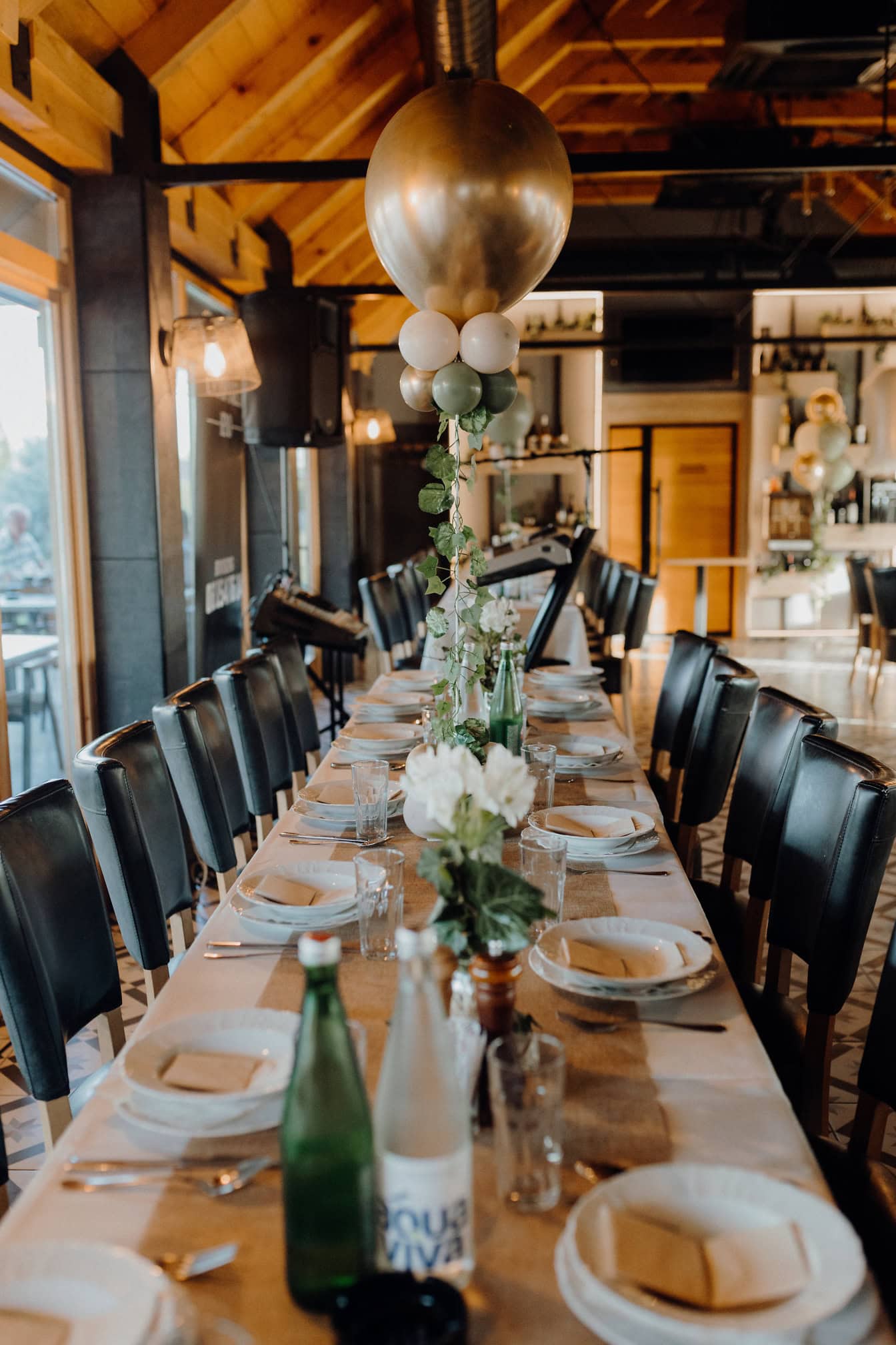 Área de jantar no restaurante com uma mesa comprida decorada com balões para almoço formal