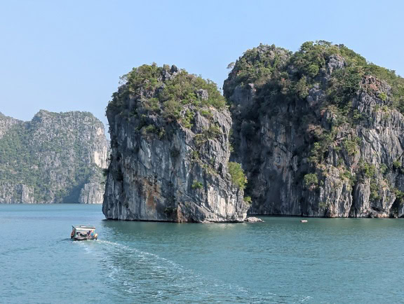 Malá turistická loď na moři u pobřeží zátoky Ha Long, Vietnam