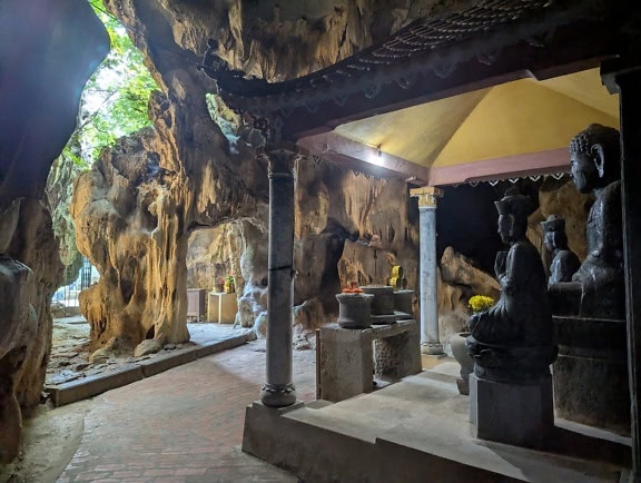 Interiör av en Bich Dong-pagod med bronsstatyer av Buddha, ett buddhistiskt tempel inuti grottan, norra Vietnam i Sydostasien