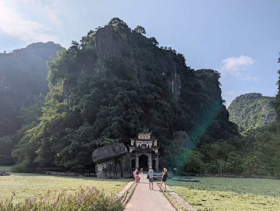 Buddhista templom Bich Dong pagoda és turisták állnak a hozzá vezető hídon