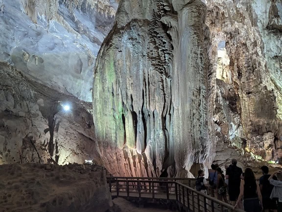 En grupp människor i en grotta observera stalaktiter som hänger i grottan, ekoturism i grottan