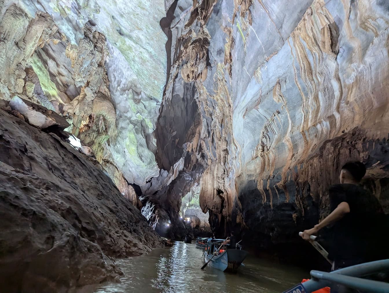 Underjordisk elv i hule, økoturismetur med turister i båt inne i Paradise-hulen, Phong Nha Ke Bang nasjonalpark ved Dong Hoi, Vietnam