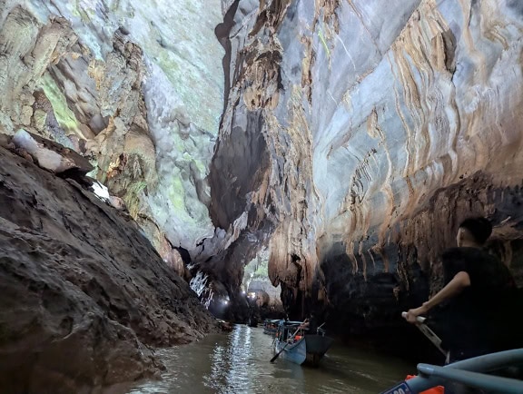 Underground river in cave, ecotourism tour with tourists in boat inside the Paradise cave, Phong Nha Ke Bang national park at Dong Hoi, Vietnam