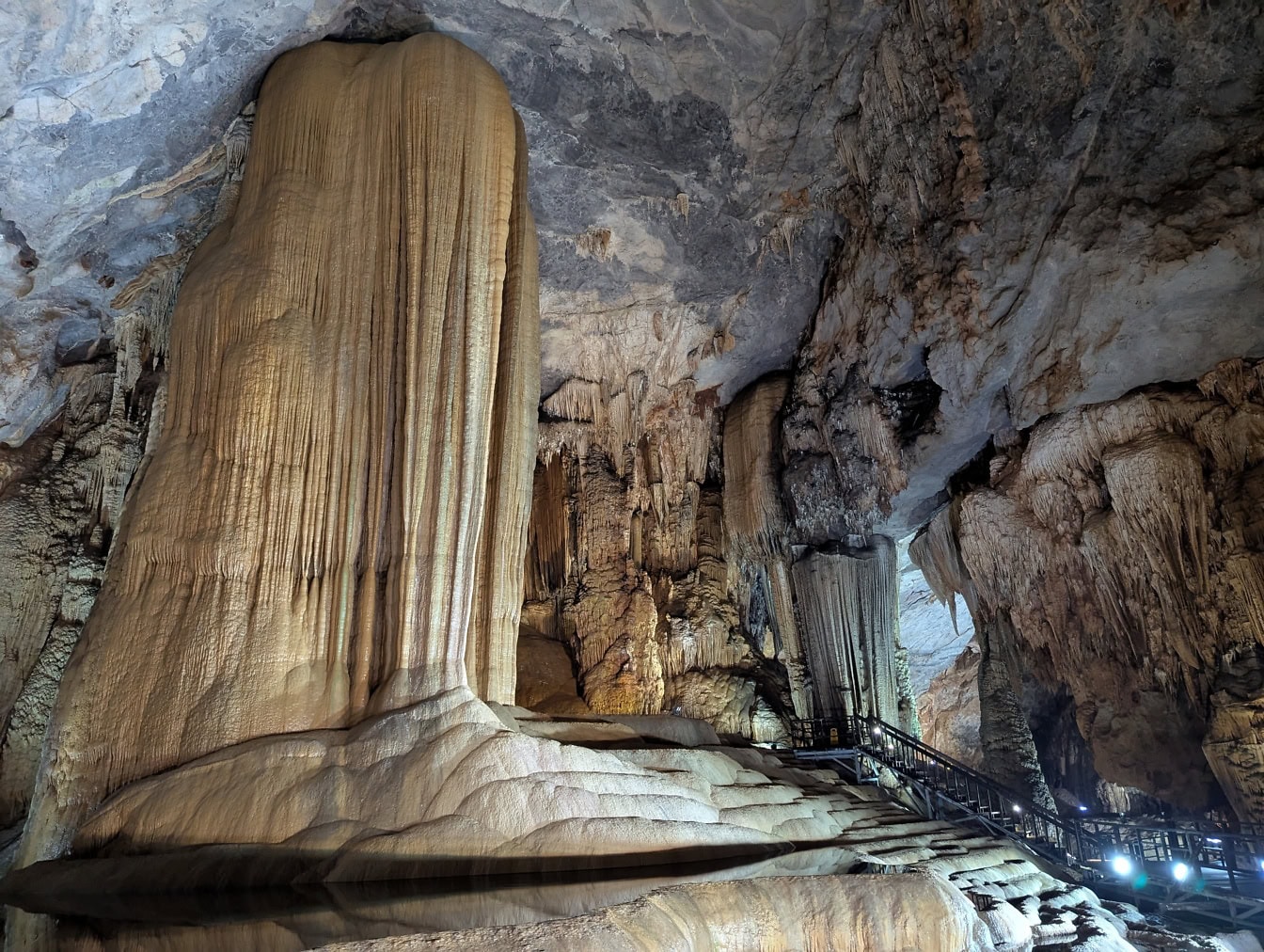 A large mineral formation in a cave made out of stalactites hanging from the ceiling and stalagmites from ground, Paradise Cave, Vietnam