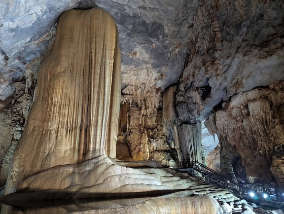 A large mineral formation in a cave made out of stalactites hanging from the ceiling and stalagmites from ground, Paradise Cave, Vietnam