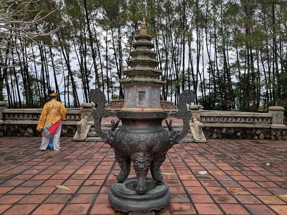 Öntött bronzszobor a Then Mu pagodában, háttérben egy buddhista szerzetessel, Vietnám