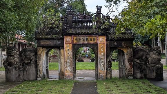 Chua Chuc Thanh, buddhista templom kőkapuval kőboltívvel a kertben, Hoi An, Vietnam