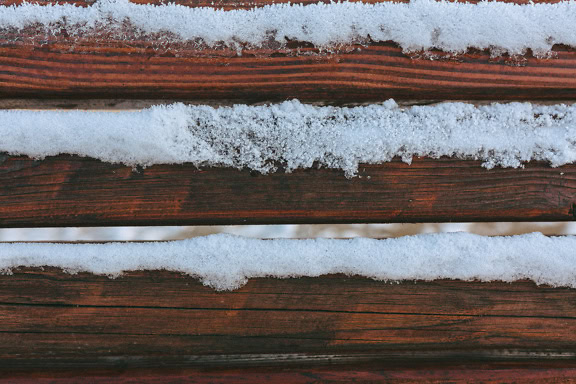 Horisontale treplanker, en tekstur av en overflate av tre med snø og frost