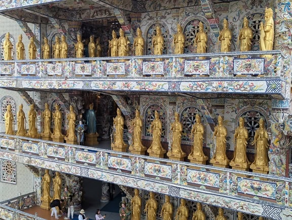 Zlaté sochy na balkoně buddhistického chrámu Linh Phuoc nebo Dračí pagody, Da Lat, Vietnam