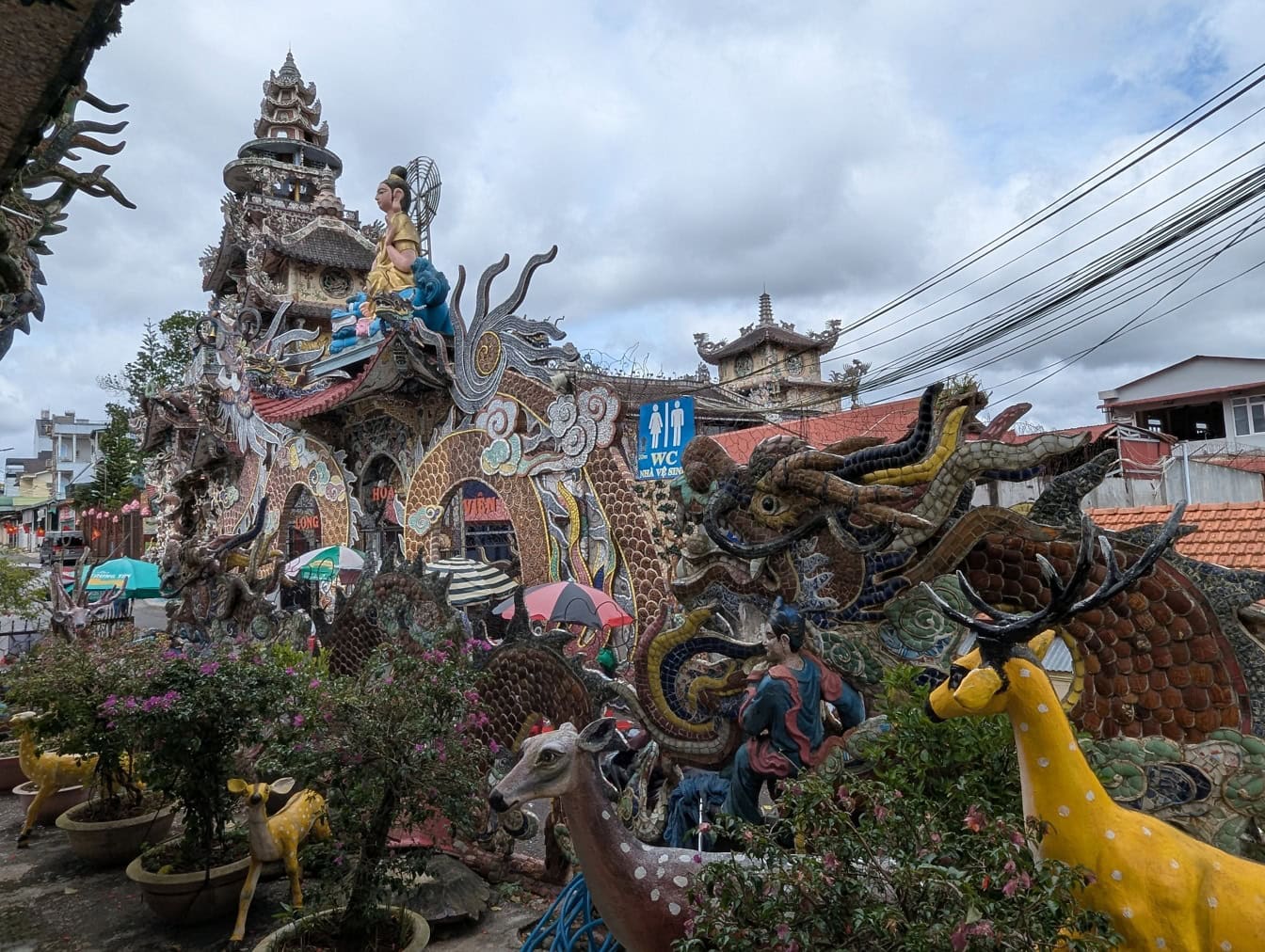 Mimoriadny exteriér chrámu Linh Phuoc alebo Ve Chai, budhistický kláštor so sochami a rastlinami v záhrade, Vietnam